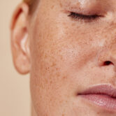 Cropped shot of the face of a young woman with freckles